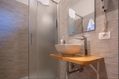 a bathroom with a bowl sink and a shower at Hotel Velus in Civitanova Marche