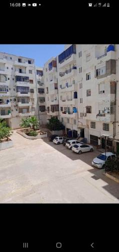 un parcheggio di fronte a un grande condominio di Appartement T3 a Aïn el Turk