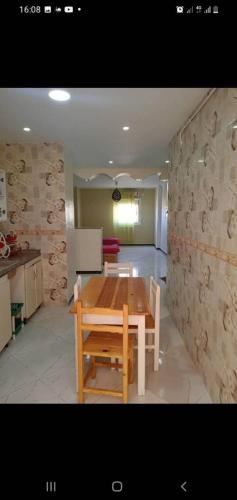 una cucina con un tavolo di legno in una stanza di Appartement T3 a Aïn el Turk