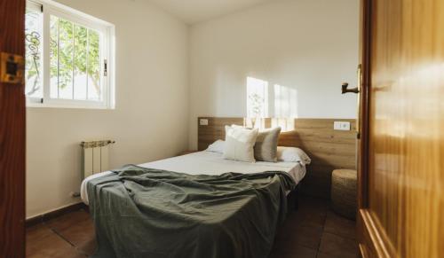 a bedroom with a bed and a window at Camping Kikopark Rural in Villargordo del Cabriel