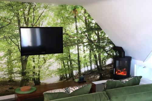 a living room with a wall mural of a forest at THE HIDEAWAY - LUXURY SELF CATERING COASTAL APARTMENT with PRIVATE ENTRANCE & KEY BOX ENTRY JUST A FEW MINUTES WALK TO THE BEACH, SOLENT WAY WALK, SHOPS and many EATERIES & BARS - FREE OFF ROAD PARKING,FULL KITCHEN, LOUNGE,BEDROOM , BATHROOM & WI-FI in Lymington