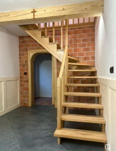 a staircase in a room with a brick wall at Modrzewiowy Zakątek in Desznica