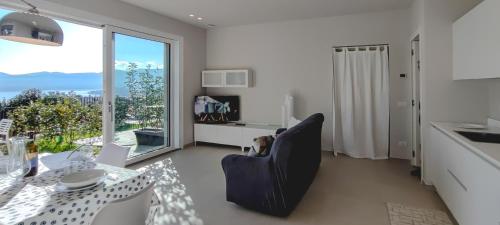 a living room with a dining room table and a window at Oasi Giardino - Pool and Lake View and Garden in Cissano