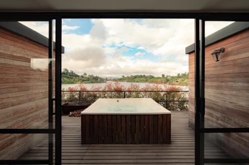 a hot tub on a deck with a view of a lake at The Boato Hotel in Guatapé