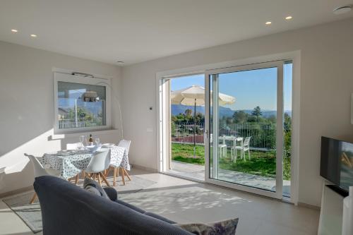 a living room with a couch and a table with a television at Oasi Giardino - Pool and Lake View and Garden in Cissano