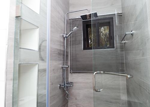 una ducha con puerta de cristal en un baño en Brielle Apartment, en Accra