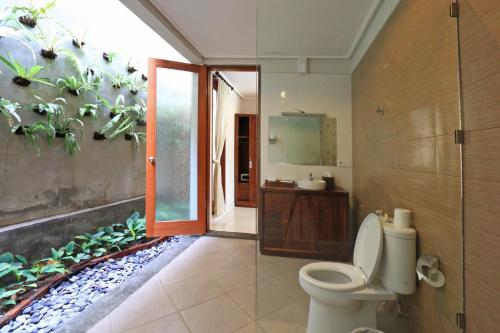 a bathroom with a toilet and a shower and a sink at Ubud Tropical Garden in Ubud