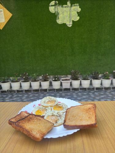 a plate of eggs and toast on a table at Paradise Inn by HBR in Dharmsala