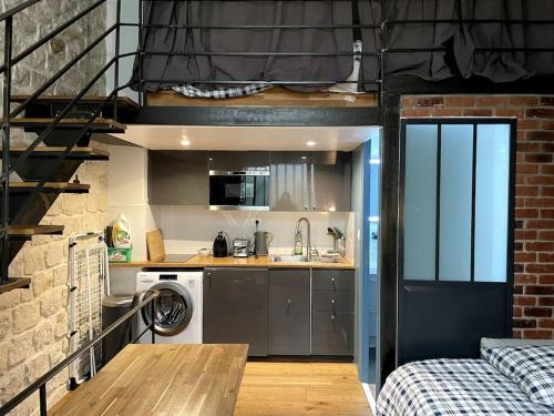 une cuisine avec lave-linge et sèche-linge dans un loft dans l'établissement Lofts Marais Reaumur, à Paris