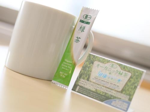 a cup and a book sitting next to a laptop at Super Hotel Midosujisen Esaka in Suita