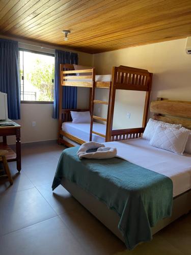 a bedroom with two bunk beds and a desk at Pousada Quatro Estrelas in Penha