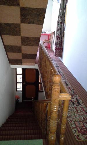 a stairway with a wooden railing in a house at Howrah Guest House in Srinagar
