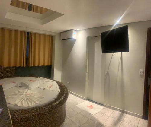a room with a bed and a television on the wall at Caribe Palace Hotel Samambaia Sul in Brasilia