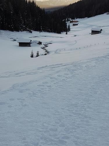 a snow covered field with houses in the distance at Casa Maria Beatrice in Mühlbach