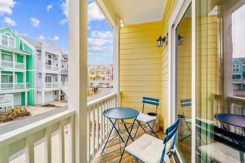 a balcony with two chairs and a table on it at The Wright Stuff OBX in Kill Devil Hills