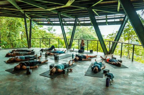 a group of people laying on the floor doing yoga at La Loma Jungle Lodge and Chocolate Farm in Bocas del Toro