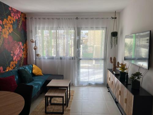 a living room with a blue couch and a window at La Chata in Costa Calma