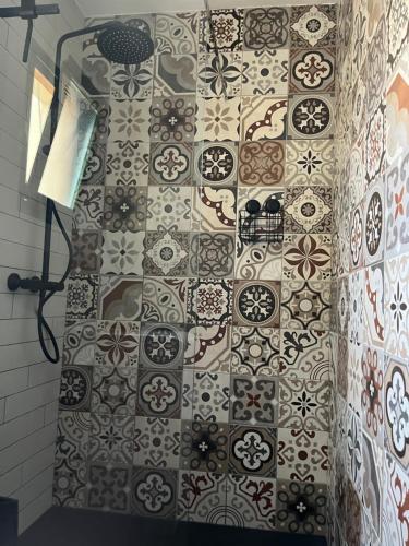 a bathroom with a tiled wall with a shower at La Chata in Costa Calma