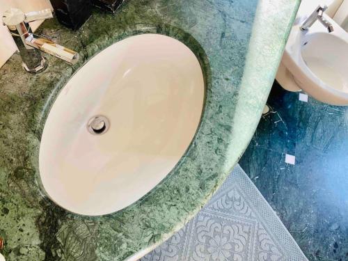 a bathroom with a white sink and a toilet at Artistic 2-bedroom condo in Milan