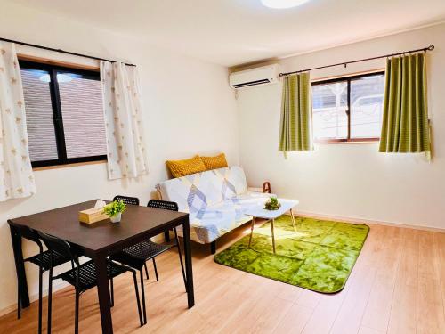 a living room with a table and a couch at 4BR Spacious Home, 10min to Umeda, 8 Guests in Osaka