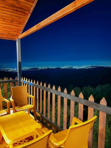a table and chairs on a porch with a view at اكواخ سفاري السياحية in Ajloun