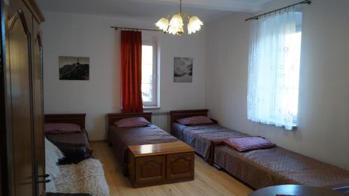 salon z 2 łóżkami i stołem w obiekcie Dom Wrzosówka w Jagniątkowie