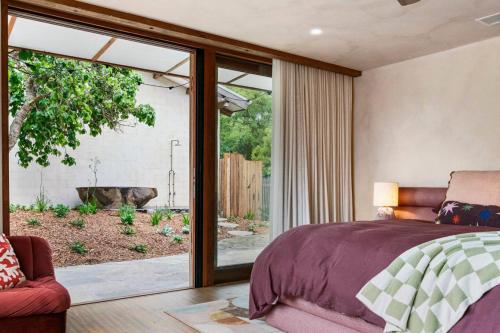 a bedroom with a bed and a view of a tub at LUXE POINT in Blairgowrie