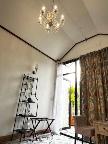 a living room with a chandelier and a window at Cozy breezing countryside Pet in Ban Khlong Sip Sam Lang