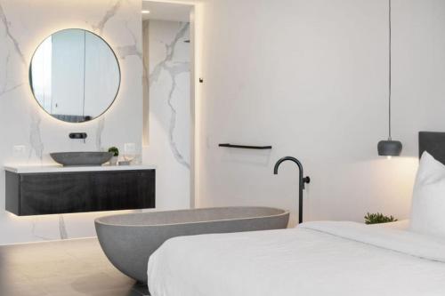 a bedroom with a tub and a sink and a mirror at VILLA BOND Mount Eliza-Incredible in every sense. in Mount Eliza
