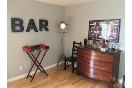 a room with a dresser and a bar sign on the wall at Central PEC gem - Craft Suite Sleeps up to 6 in Picton