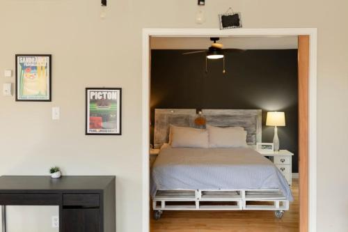 a bedroom with a bed and a black wall at Central PEC gem - Craft Suite Sleeps up to 6 in Picton