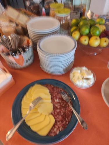a table with a plate of food with cheese and fruit at Hotel Villa al Mare in Ischia