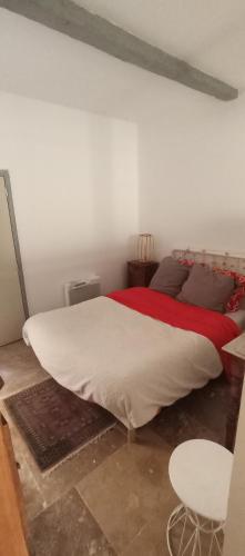 une chambre avec un grand lit avec une couverture rouge dans l'établissement Appartement cosy rue HAGUENOT proche Arceaux, à Montpellier