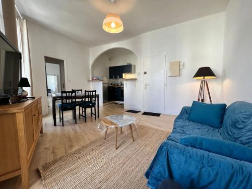 a living room with a blue couch and a table at Saint Goustan à pied! Joli appartement 2p in Auray