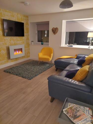 a living room with a couch and a fire place at Hill Street Cottage in Portpatrick