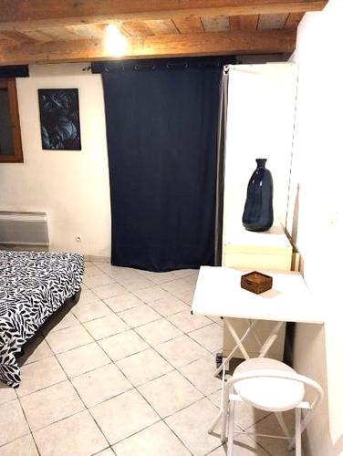 une chambre avec un lit, une table et une chaise dans l'établissement Charmant studio, à Cabriès