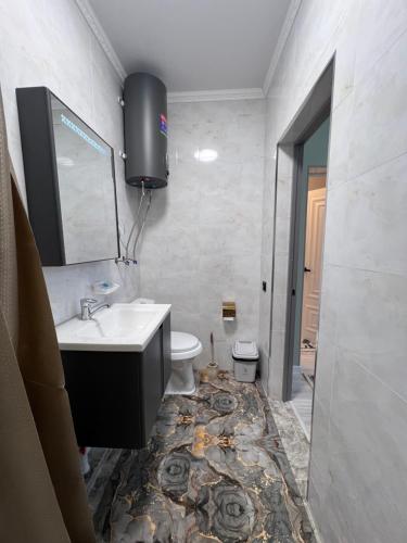 a bathroom with a sink and a toilet at MARAL GuestHouse in Karakol