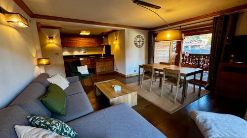 un salon avec un canapé et une table dans l'établissement Appartement 2 Chambres Residence Le Mont Chéry Au Pied des Pistes Plein Centre, aux Gets