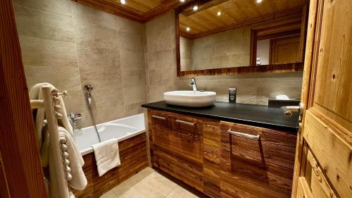 une salle de bain avec un lavabo et une baignoire dans l'établissement Appartement 2 Chambres Residence Le Mont Chéry Au Pied des Pistes Plein Centre, aux Gets