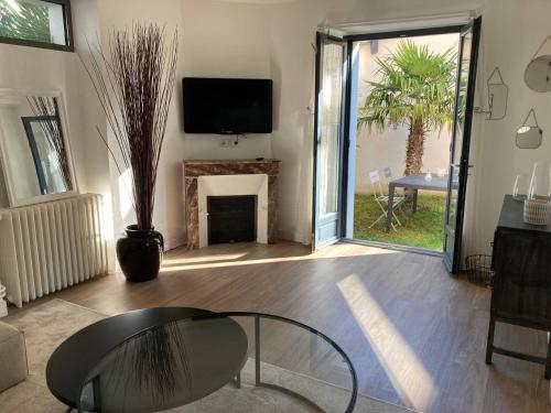 - un salon avec une table en verre et une cheminée dans l'établissement La Maison de Léa, à Périgueux