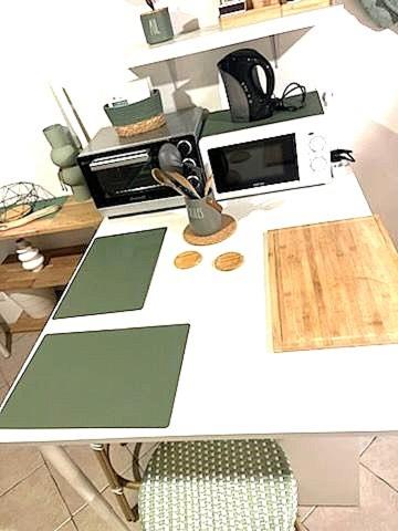 un comptoir blanc avec un four micro-ondes et une chaise dans l'établissement Joli studio meublé, à Cabriès