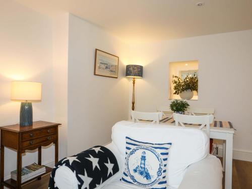 a living room with a white chair and a table at Cwrt in Dwyran