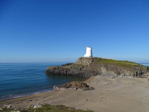 a lighthouse on a small island in the ocean at Cwrt in Dwyran