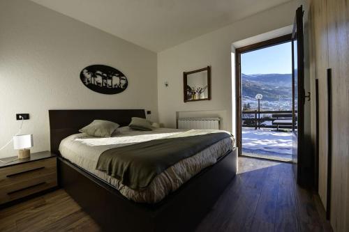 a bedroom with a bed and a door to a balcony at Le Jardin des Montagnes in Morgex