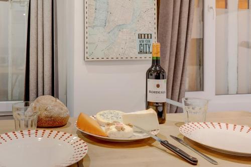 - une bouteille de vin assise sur une table avec des assiettes dans l'établissement Bluestay 200 - Superb apartment, à Paris