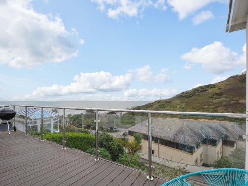 a balcony of a house with a view of the ocean at Waves Edge in Torpoint