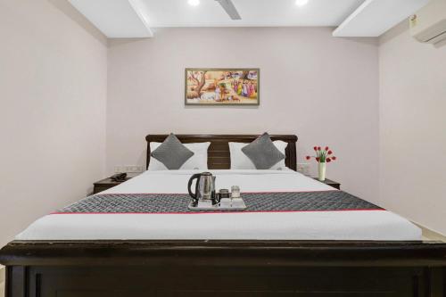 a bedroom with a bed with a tea kettle on it at Super Townhouse RCC PARK VIEW INN in Hyderabad