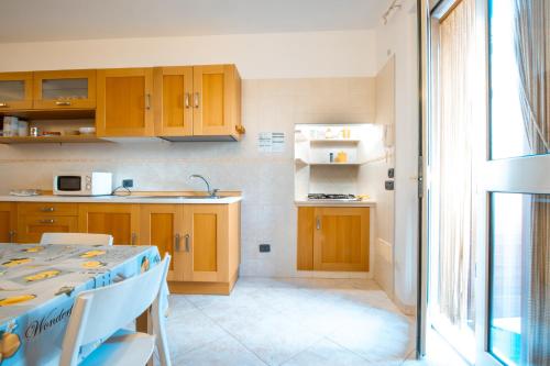 a kitchen with wooden cabinets and a table with chairs at Adua Apartment in Polignano a Mare