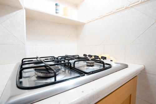 a gas stove top in a white kitchen at Adua Apartment in Polignano a Mare