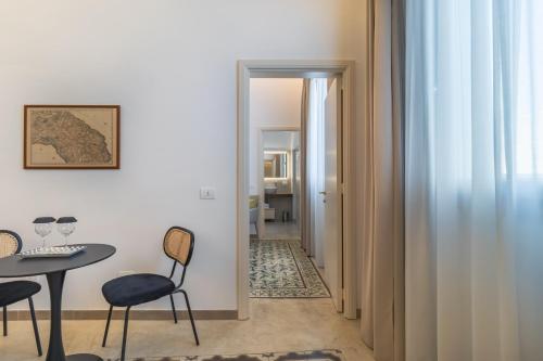 a room with a table and chairs and a hallway at Palazzo San Lazzaro - Jacuzzi Rooms & Suites Lecce Selection in Lecce
